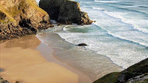 A coastal beach with rocky cliffs and waves crashing onto the shore. - Cosy, Quiet Static Caravan, Mawgan Porth, St Eval (Wadebridge)