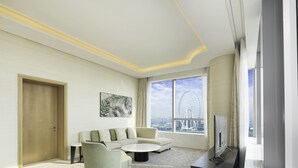 Een moderne hotelkamer met een groot raam met uitzicht op de stad, een bank, een bijzettafeltje en een flatscreen-tv.