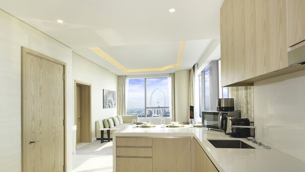 Een moderne keuken met een groot eiland, inbouwapparatuur en uitzicht op een reuzenrad.