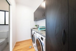 A laundry area with a washing machine and dryer, a sink, and a cabinet.
