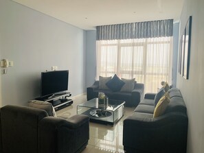 Relax in this stylish living room with a flat-screen TV, comfortable sofas, and a beautiful view.