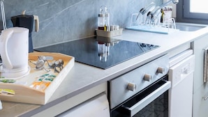 Una cocina moderna con microondas integrado, un lavamanos de acero inoxidable y un horno negro.