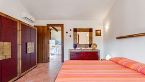 Un dormitorio con una cama grande, un armario de madera, un tocador y un espejo.