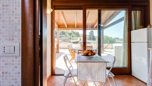 Una cocina con una mesa de comedor, sillas y un frutero.
