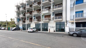 Un edifici de diverses plantes amb balcons i una entrada tancada per una reixa.