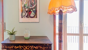 A wooden table with a decorative pattern, a framed artwork, and a potted plant. - La Terrazza Di Siracusa - Roomy And Bright Flat (Syracuse)