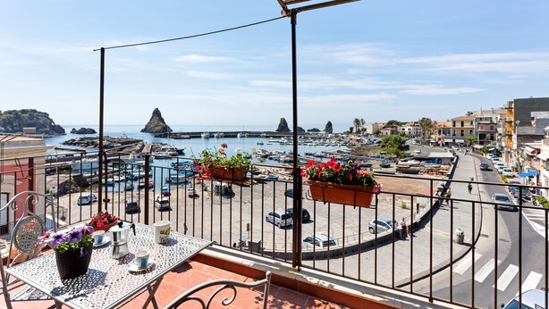 Een balkon met uitzicht op een jachthaven, boten en gebouwen.