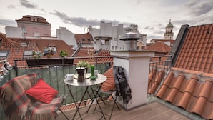 A rooftop terrace with a table, chairs, and a view of the cityscape. - Charming APT Old Town Prague (Prague)