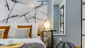 A modern bedroom with a bed, bedside table, lamp, and a view of a bathroom. - Charming APT Old Town Prague (Prague)
