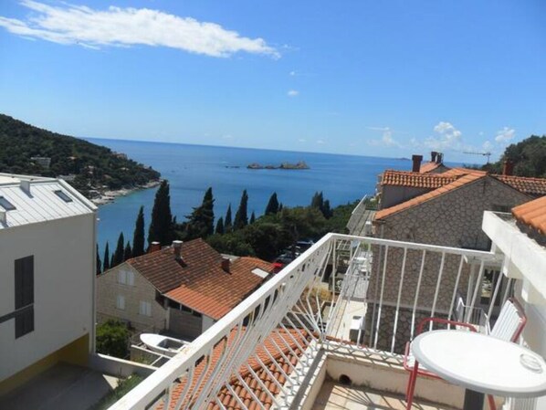 A balcony with a view of the sea and a distant island.