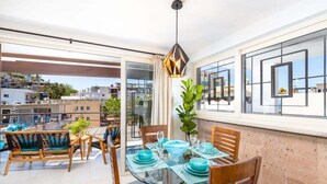 A modern dining area with a glass table, blue plates, and wooden chairs. - Casa Turquesa - Private Pool! Local Neighbourhood (Puerto Vallarta)