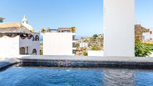 A rooftop pool with a tiled edge, white buildings in the background, and a clear blue sky. - Casa Turquesa - Private Pool! Local Neighbourhood (Puerto Vallarta)