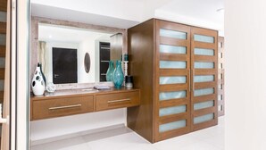A modern bathroom with a wooden vanity, a large mirror, and a glass-fronted cabinet. - Casa Turquesa - Private Pool! Local Neighbourhood (Puerto Vallarta)