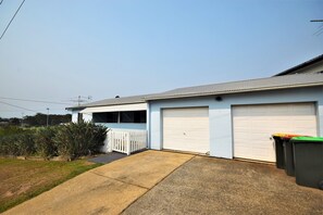 A single-story house with a garage, a covered porch, and a front yard.