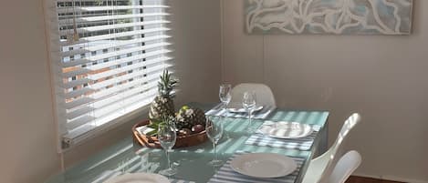 A dining table set with plates, glasses, and a centerpiece of pineapples.