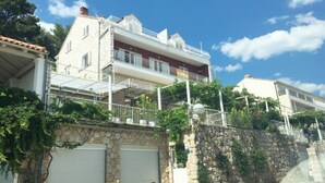 Um edifício de dois andares com fachada de pedra, garagem e varanda.
