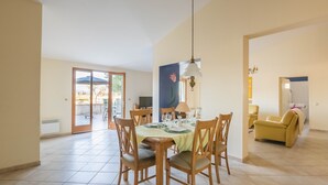 Un espace repas comprenant une table ronde, des chaises et un luminaire suspendu.