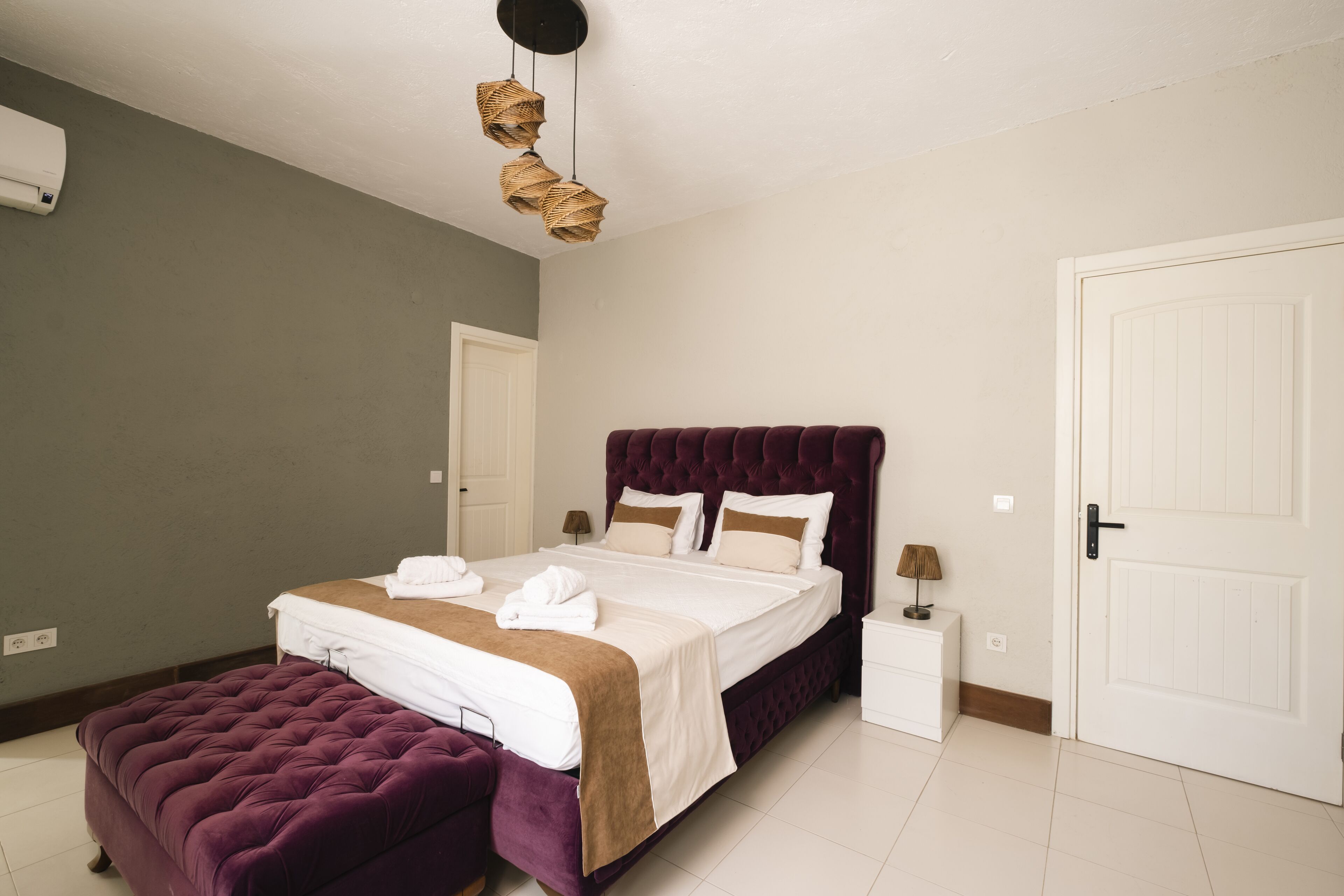 Une chambre bien rangée, avec un grand lit, une table de chevet, une lampe et une armoire.