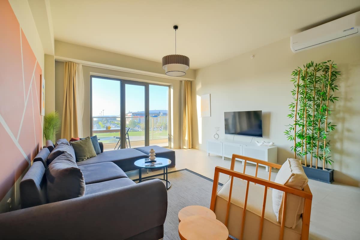 A modern living room with a sofa set, a coffee table, and a TV.