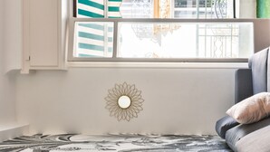 Une pièce dotée d’une grande fenêtre, d’un élément décoratif mural et d’un tapis à motifs.