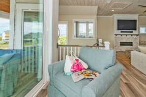 Una sala de estar con un sofá, un televisor y una chimenea.