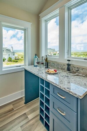 Una cocina con encimera de mármol, cajones integrados y vistas a la playa.