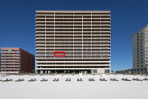 A multi-story hotel with a uniform exterior, a central entrance, and a beachside location with sun loungers. - CSW206 – Top-Rated Comfort – Guest-Praised "Nicest Unit" – Gulf Front – 2 Kings (Gulf Shores)
