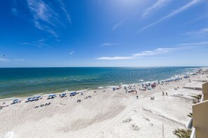 A beach with white sand and clear blue water.