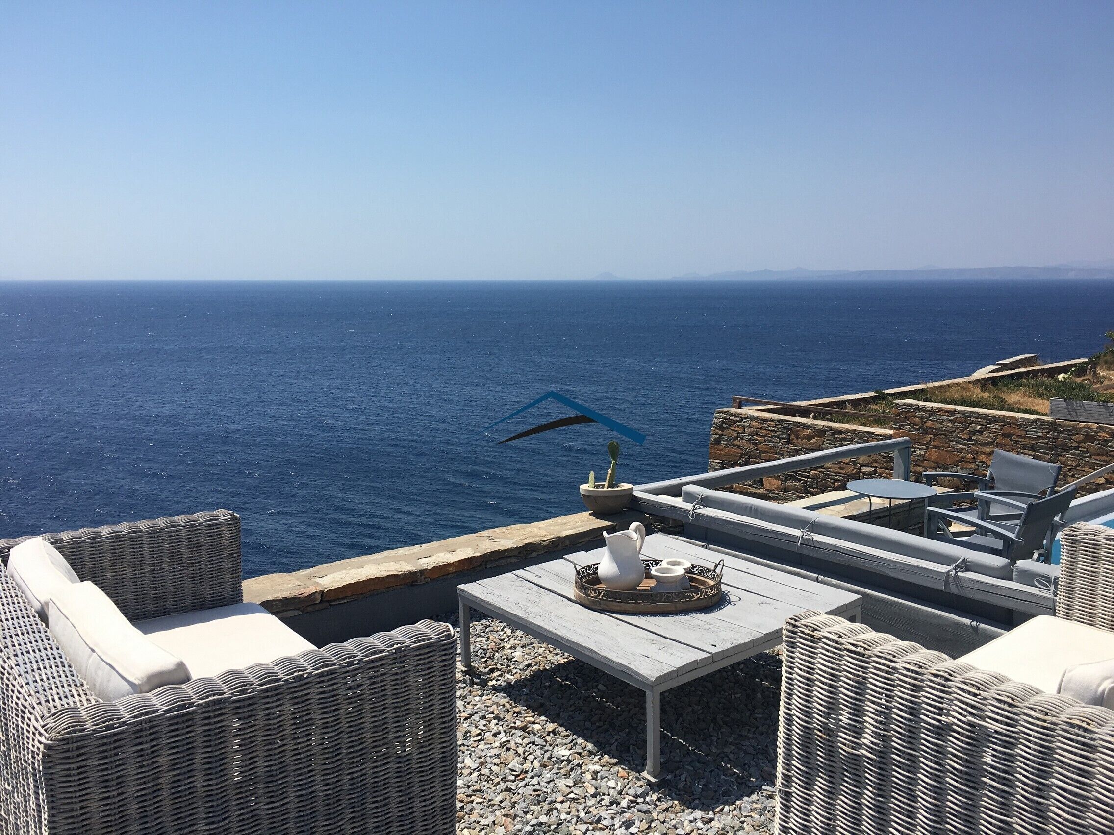 A seating area near the pool with a panoramic sea view
