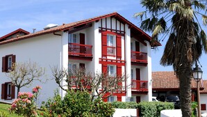 A two-story building with red balconies and white walls.