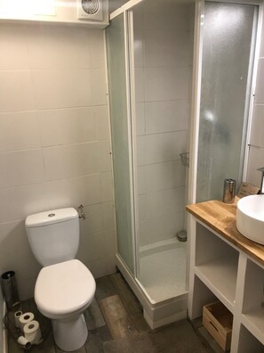 Een douche, handdoeken, zeep, toiletpapier
