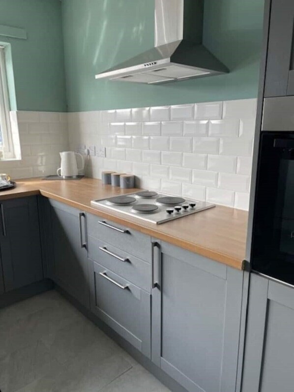 Enjoy cooking in this well-equipped kitchen with a stovetop, oven, and range hood.