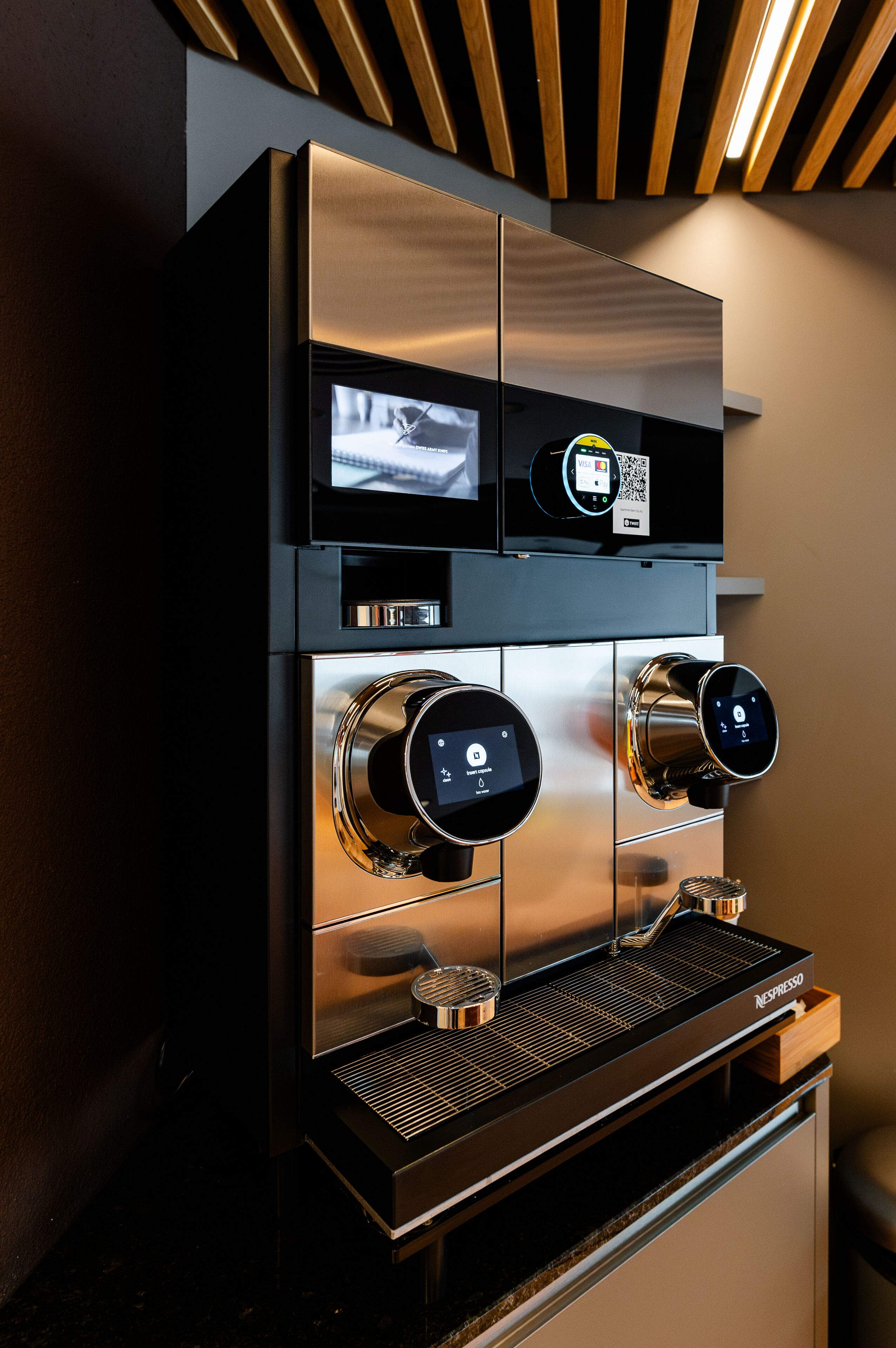 A modern espresso machine with a digital interface and a QR code.