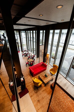 A modern interior with a red sofa, yellow chairs, and a wooden coffee table. - Los Lorentes Residences (Bern)