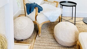 A cozy room with a wooden chair, a small round table, and a hanging light fixture. - * Fisherman’s Cottage * with river views (Appledore)
