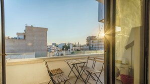 A balcony with a view of the cityscape, featuring a table and chairs. - Fanta Sea Apartment (Larnaca)