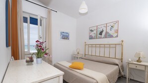A bedroom with a bed, bedside tables, a desk, a window with curtains, and a wall with a framed picture. - Historic Seafront Villa, 10 meters from the sea on the Tyrrhenian coast (Rosignano Solvay-Castiglioncello)