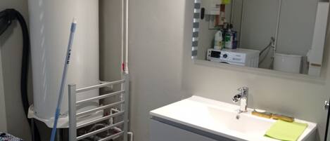 A bathroom with a white sink, a mirror, and a towel rack.