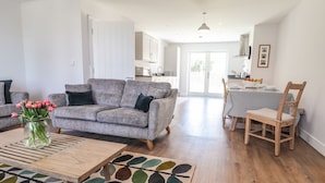 A modern living room with a grey sofa, a coffee table, and a colorful rug. - Ty Owen (Bangor)