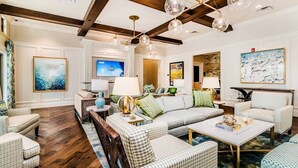 A spacious living room with a large sectional sofa, multiple armchairs, a coffee table, and a television. - Modern Decor With Themed Rooms, With Retro Game Room and Huge Pool in Upscale Resort! #6s820 (Kissimmee)