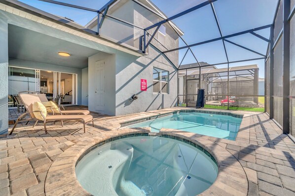 A swimming pool area with lounge chairs and a covered patio.