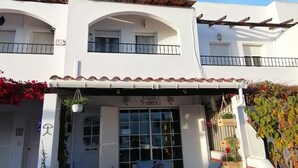 A two-story building with a white facade, a balcony with seating, and a sign reading "Casa Owen". - Amazing house: beach, pool, BBQ, views ❤️🏖️ (Mojácar)