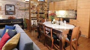 Una sala de estar acogedora con un sofá, una mesa de comedor y una cocina con armarios de madera y estufa.