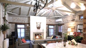 Una sala de estar acogedora con chimenea, sofás y una mesa de comedor.