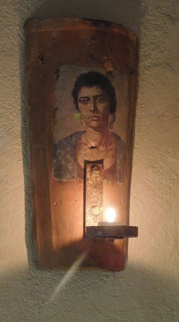A wooden plaque with a portrait and a rectangular object in front of it.