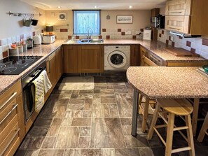 A compact kitchen with a built-in washing machine, a stove, and a sink.