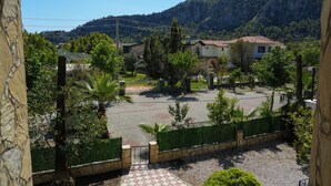 A residential area with houses, a paved courtyard, and a mountainous backdrop. - Sirius Star (Ortaca)