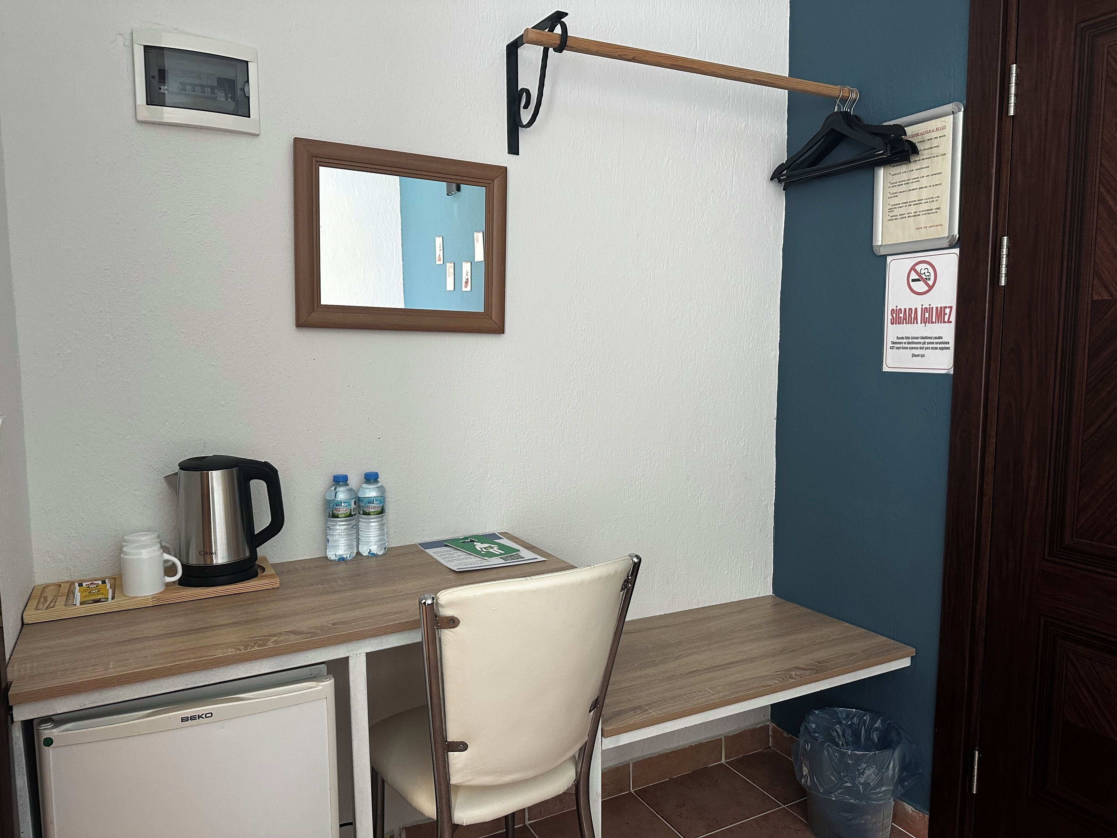 A small kitchenette with a coffee maker, water bottles, and a kettle.
