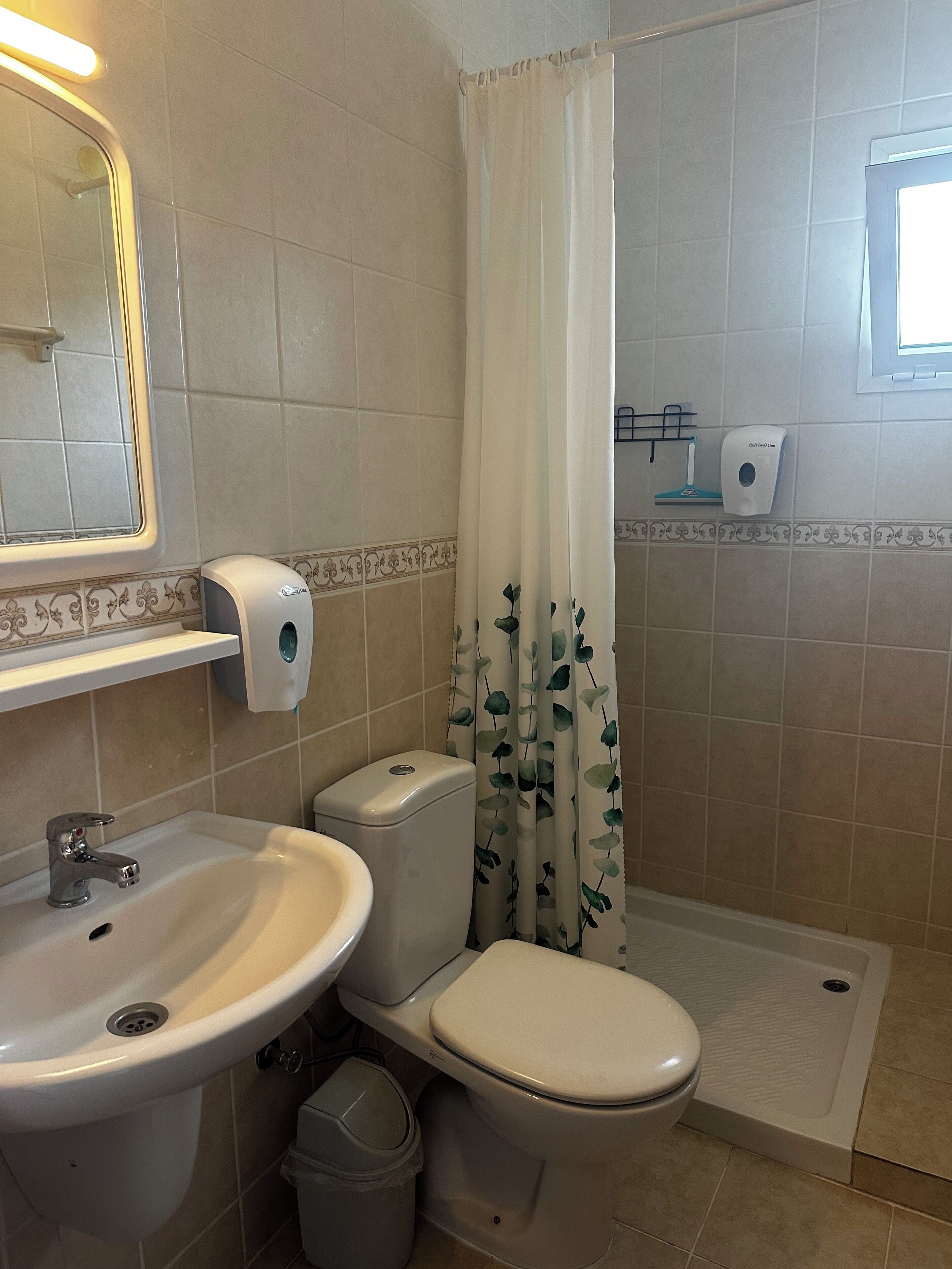 A bathroom with a sink, toilet, and shower.