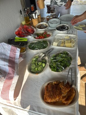 Una mesa de buffet con diversos alimentos y utensilios.